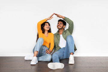 Indian couple holding hands, forming roof shape