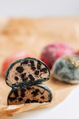 Half colored mochi on wooden board on white background.