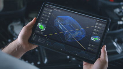 Automotive engineer holds digital tablet computer with simulation of real-time car diagnostics displayed on screen. 3D graphics visualization of professional software with 3D virtual electric vehicle