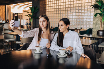 Two pretty girls sitting in a cozy coffee shop