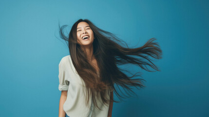 Portrait of beautiful asian woman with flying long hair in casual wear. - obrazy, fototapety, plakaty