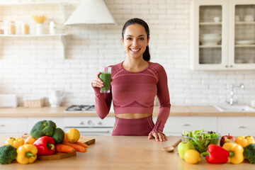 Fit woman enjoying freshly made smoothie in her cozy kitchen