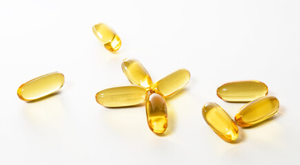 Cod liver oil omega 3 capsules were scattered on the white floor.
