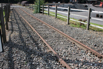 Tramway line with raised iron tramway tracks, gravel and fence enclosure