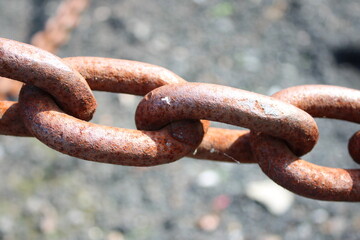 Close up picture of large heavy rusted iron chains