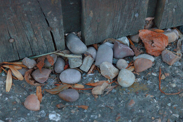 Bunch of pebbles on asphalt pavement with dead leaves