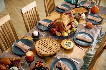 Thanksgiving turkey and pie on decorated table in dining room.