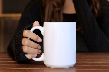  Girl is holding white 15 oz mug in hands with black sweater . large, big, 15oz  blank ceramic cup copy space

