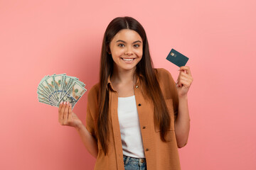Teenage girl holding credit card and cash, contemplating financial choices - obrazy, fototapety, plakaty