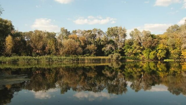 Autumn landscape. View of the river and forest in autumn at sunset.