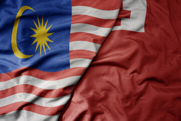 big waving realistic national colorful flag of malaysia and national flag of Tonga .