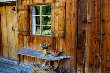 rustic countryside scenery with an old yellow vase with field flowers and red apples in the basket...