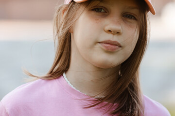 Close up portrait of a ten year old girl, smiling up at the camera. Positive emotion
