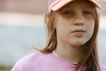 Close up portrait of a ten year old girl, smiling up at the camera. Positive emotion