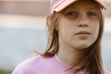 Close up portrait of a ten year old girl, smiling up at the camera. Positive emotion