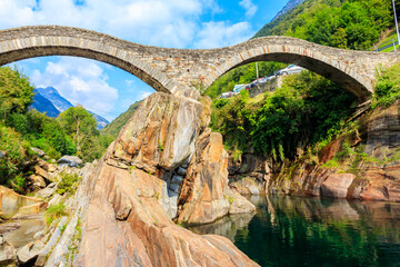 Ancient double arch stone Roman bridge (Ponte dei Salti) over the clear water of the Verzasca river in Lavertezzo ,Verzasca Valley, Ticino Canton, Switzerland