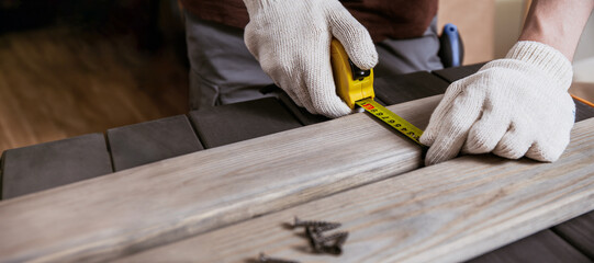Banner of Carpenter Measuring a Wooden Plank by ruler in wooden workshop, carpenter measuring...