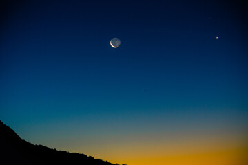 Crescent moon at twilight with the morning star Venus.