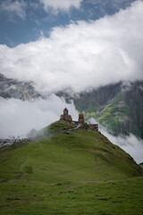A view of the iconic Trinity Church in Stepantsminda surrounded by low clouds