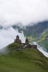 A view of the iconic Trinity Church in Stepantsminda surrounded by low clouds