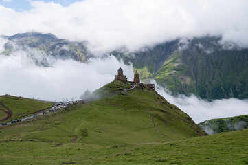 A view of the iconic Trinity Church in Stepantsminda surrounded by low clouds