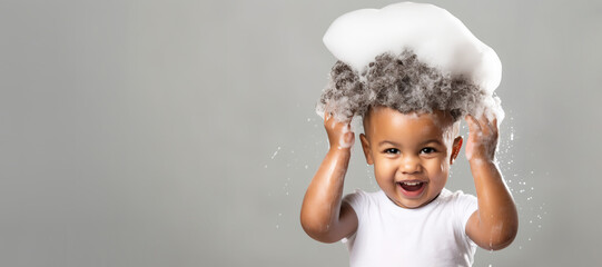 banner copyspace Little smiling african American baby boy with big soap foam on head in hair on solid grey background, Kids hygiene, Shampoo, hair treatment and soap for children, childs bathing time - obrazy, fototapety, plakaty