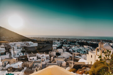 Sunrise in Oia, Santorini, Greece. Sun is rising behind the mountains above the traditional village...