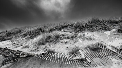 Beach Landscape with dune and a fence on land, in Black and White.