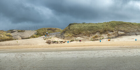 Panorama of a coast at low tide. An abandoned WW2 bunker and silted dunes. Coastline of Upper Normandy, France
