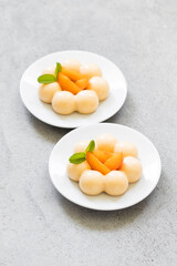 Modern Apricot cream mousse dessert,  in the shape of truffles, decorated with fresh apricot slices. Top view