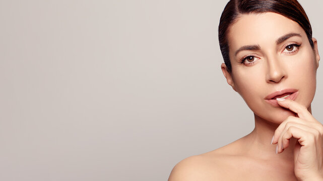 Natural Beauty Portrait Of Middle Aged Woman With Brown Hair, Showing Healthy And Hydrated Human Skin For Rejuvenating Skin Care Treatment.