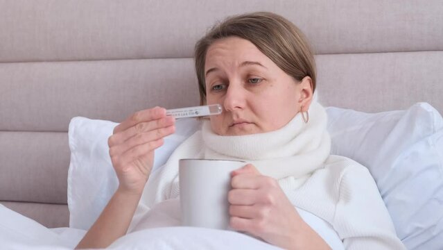 Sick woman lying in bed with high fever. Cold flu and migraine. Headache virus.