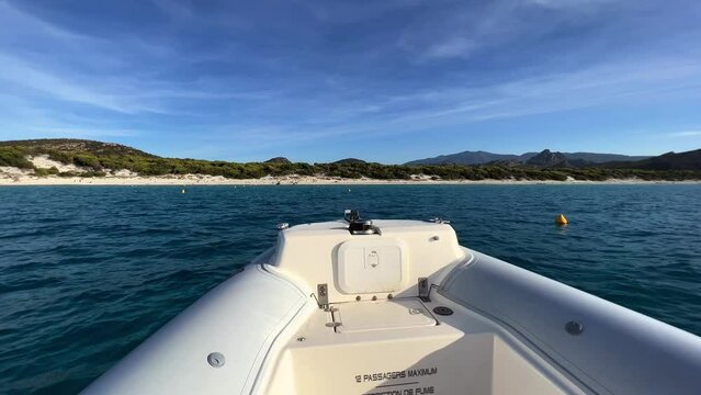 POV of motorboat bow navigating toward Saleccia beach in Corsica island in France