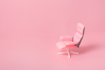 Doll office chair on a pink background. Monochrome business concept