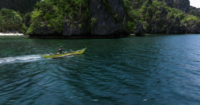 Drone view above the sea following a traditional boat in El Nido, Philippines