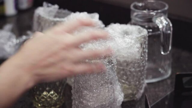 Organizing glass cups in the kitchen. Removing bubble wrap from glass cups
