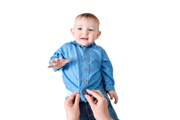A mother woman wears a blue shirt to a baby boy, isolated on a white background. Mom dresses a happy child in clothes. Kid nine months old