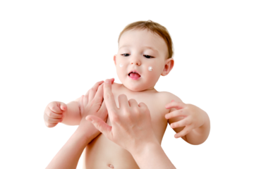 The mother smears the face of the toddler baby boy with cosmetic cream, isolated on a white background. Mom hands apply cream to the child skin, isolated on a white background. Kid aged one year