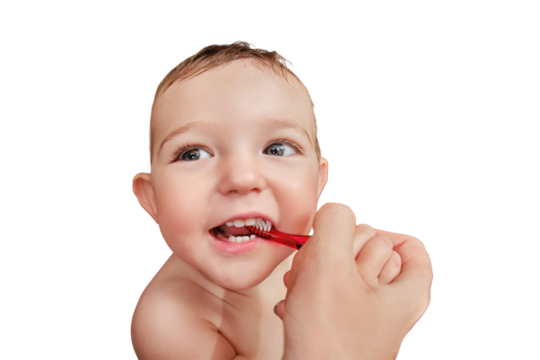 Mother brushing teeth to happy toddler baby boy, isolated on a white background. Mom woman brushes teeth to a smiling child, isolated on a white background. Kid age one year