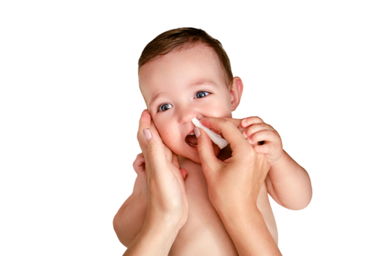 A mother cleans her nose with a twisted cotton pad to a happy toddler baby boy, isolated on a white background. Mom cleans the nostrils of a smiling child. Kid age one year