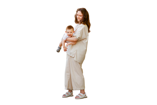 Mother holds a happy toddler boy boy in her arms, isolated on a white background. Mom with a smiling baby in white clothes, one year old kid