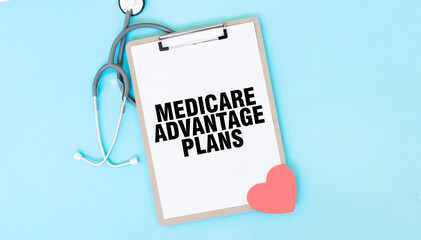 Grey stethoscope and paper plate with a sheet of white paper with text MEDICARE ADVANTAGE PLANS...