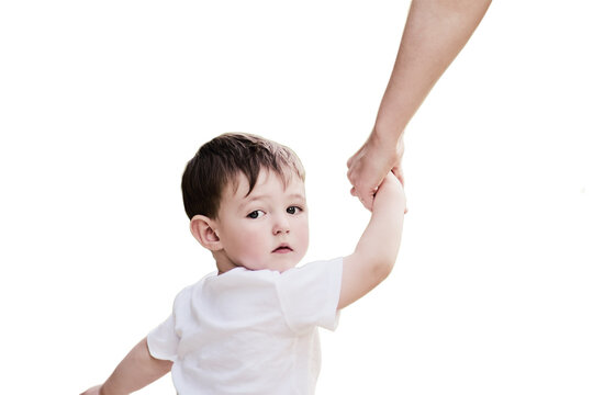 Child boy looks back with fear in his eyes, clutching his mother's hand tightly, isolated on white background. Little baby feels a mix of emotions as he looks back at his mom