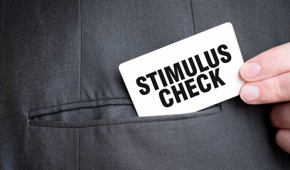 Card with STIMULUS CHECK text in pocket of businessman suit. Investment and decisions business concept.