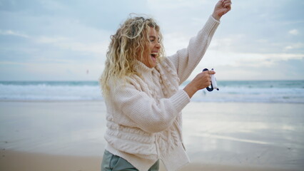 Fototapeta na wymiar Romantic girl holding kite string at beautiful ocean view. Cheerful mother play