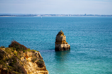 View of idyllic nature landscape with rocky cliff shore and waves crashing on. Camillo beach in...