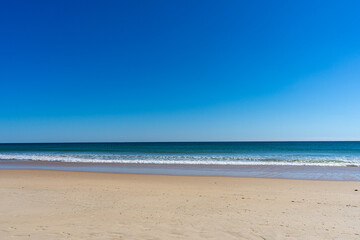 View of idyllic nature landscape with huge beaches and waves crashing on. Manta Rota beach. West Atlantic coast of Algarve region, south of Portugal.