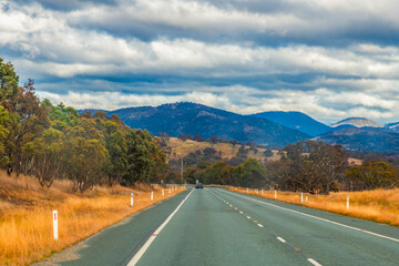 Road trippin through the dry countryside under a blue sky with clouds