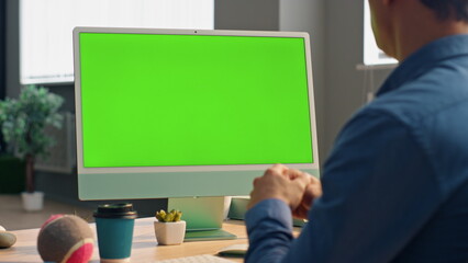 Manager talking mockup computer at video call. Unknown man looking green screen