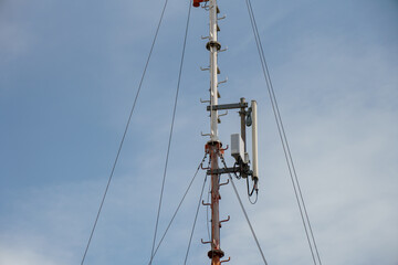 New GSM antennas on a high tower against a blue sky for transmitting a 5g signal are dangerous to health. Radiation pollution of the environment through cell towers. The threat of extinction